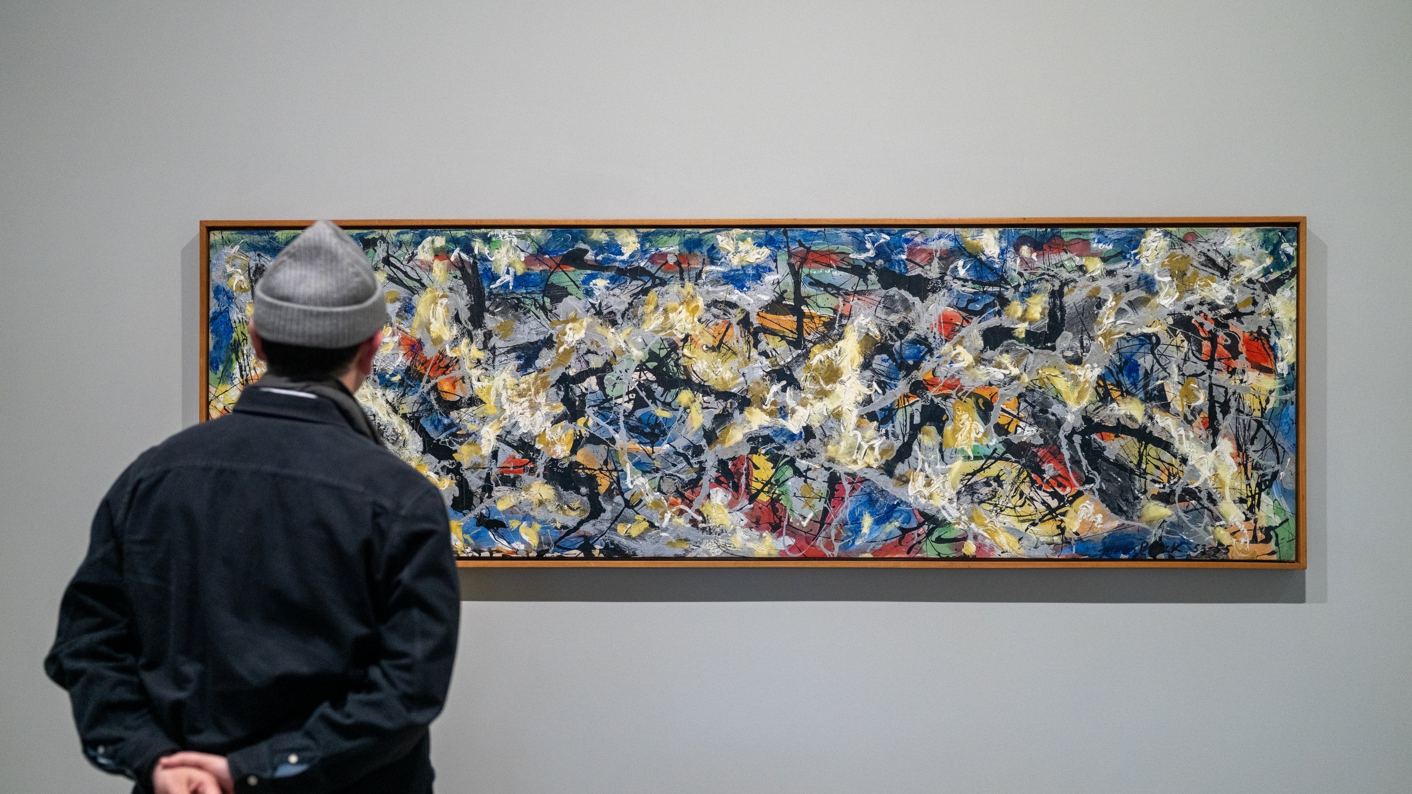 Man looks at an all-over abstract expressionist painting