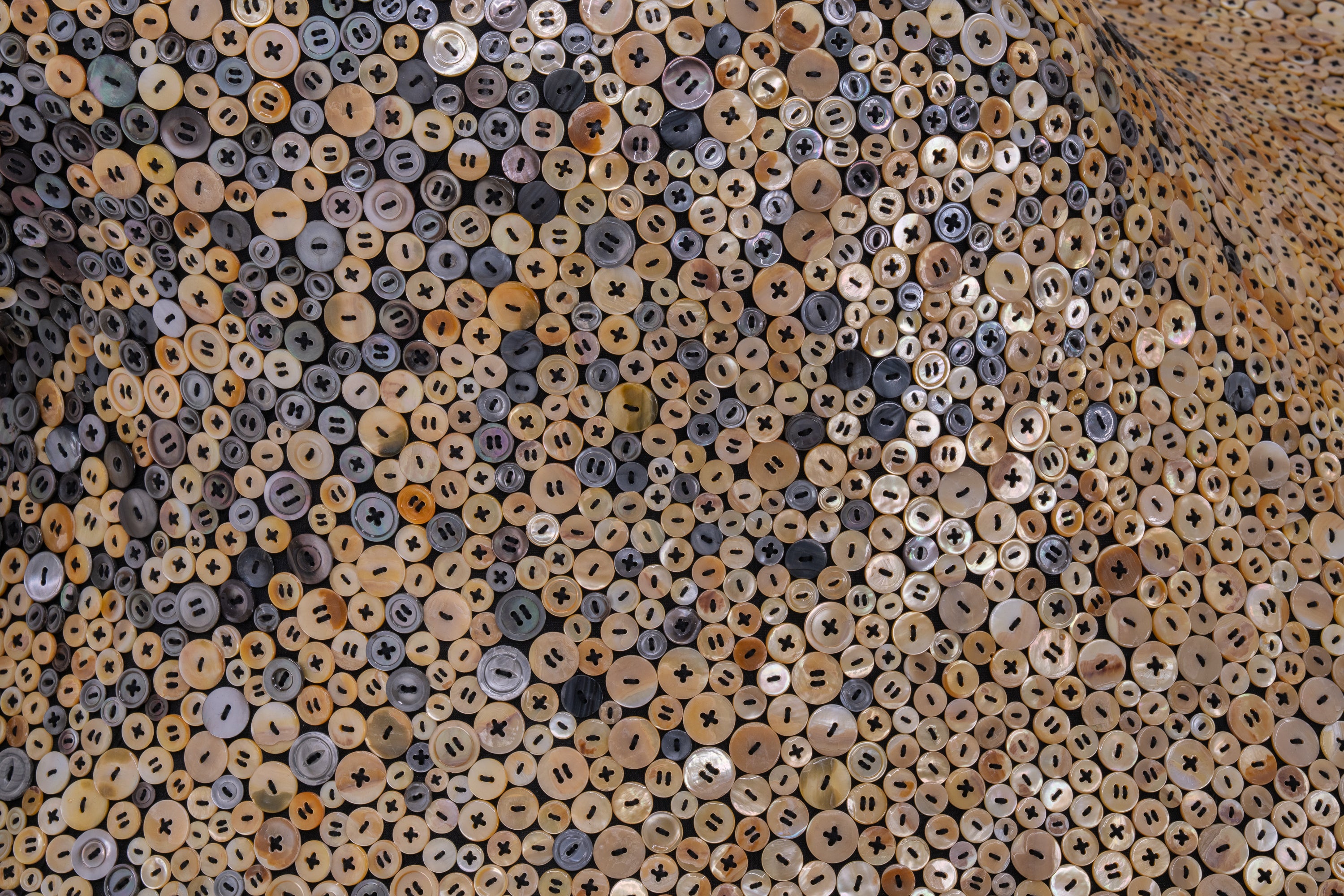 A close up photo of a cascade of iridescent buttons