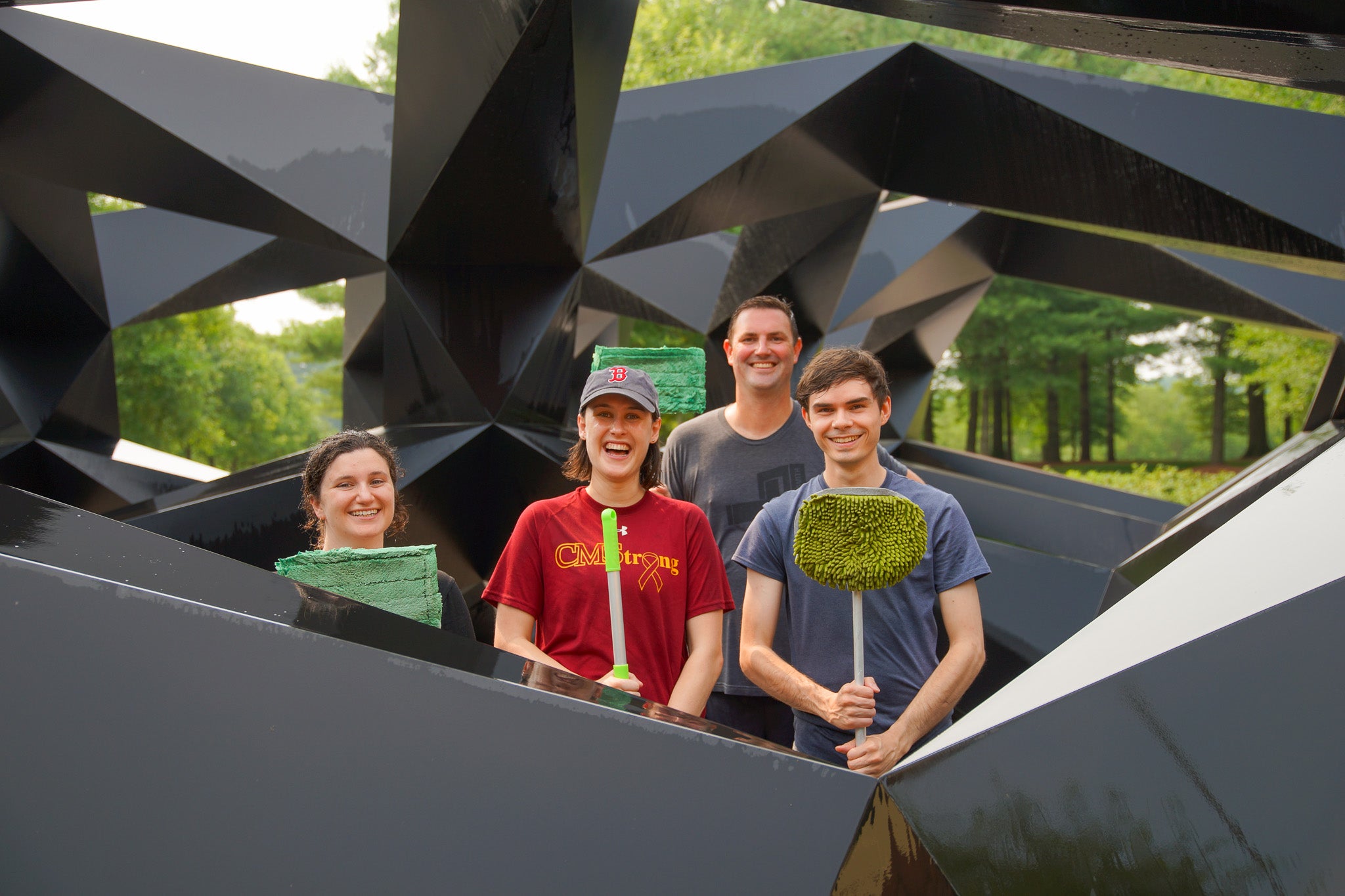 Personas de pie en una escultura con herramientas de lavado