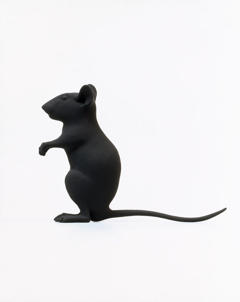 An all black mouse stands on its back legs.