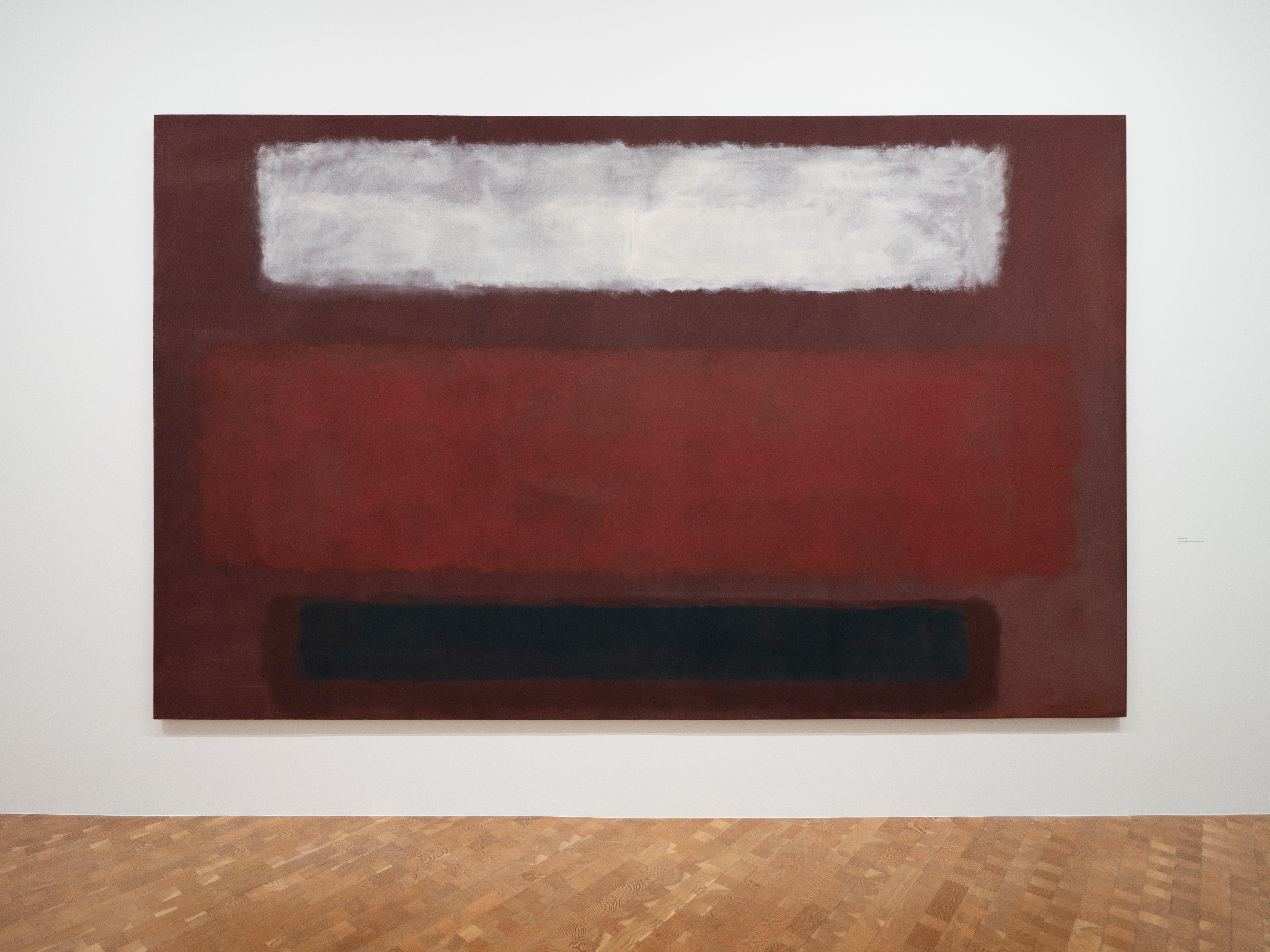 Una gran pintura abstracta de pintura blanca y negra sobre un fondo rojo