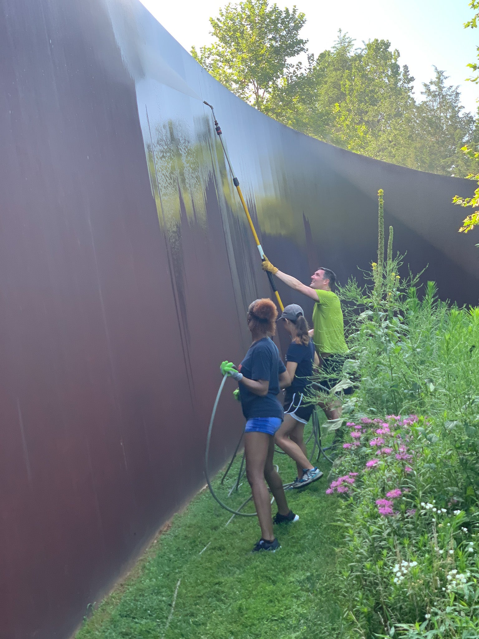Un grupo de personas lava una escultura al aire libre