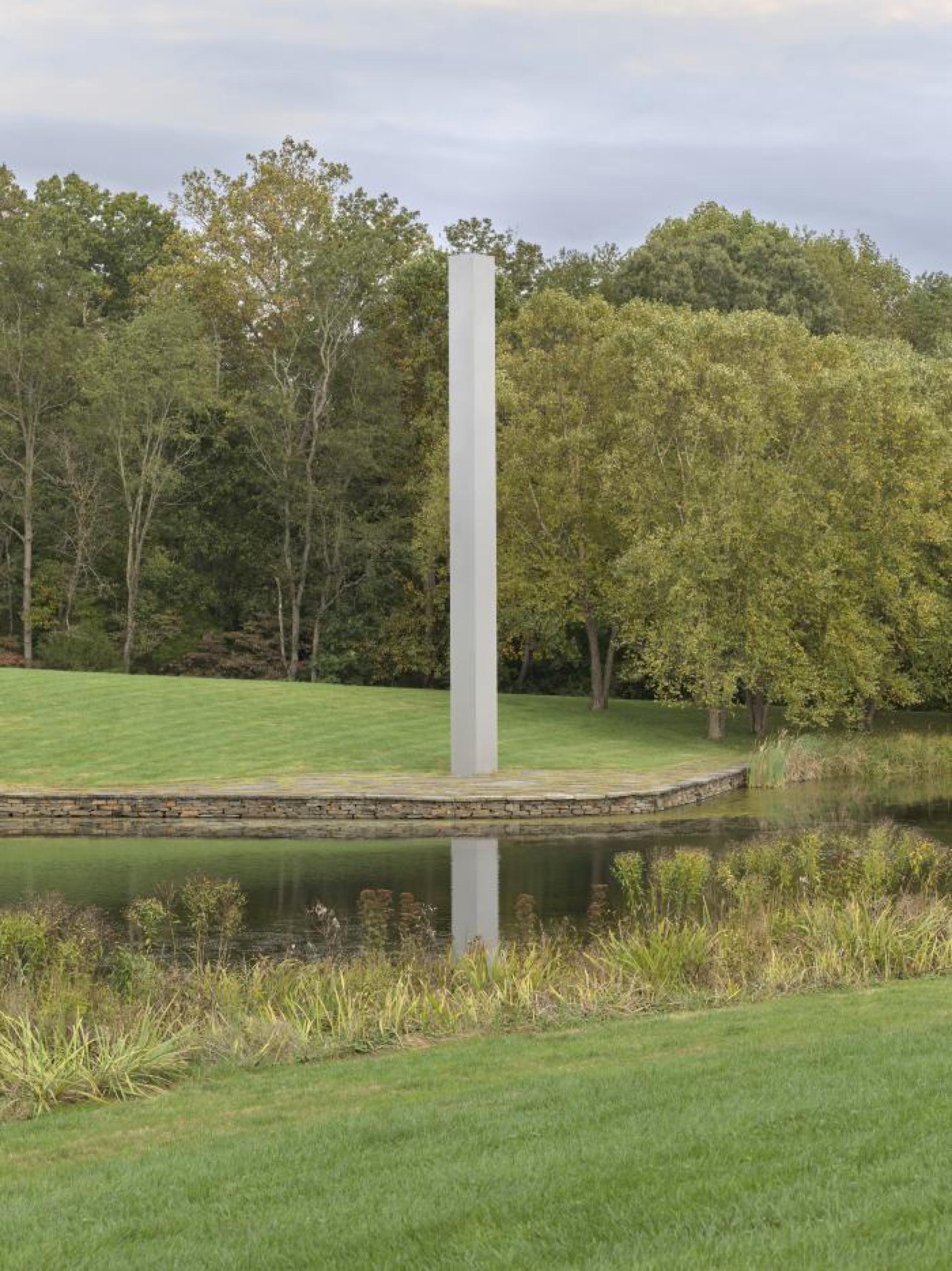 Un alto rectángulo de acero se encuentra en el borde derecho de un estanque.