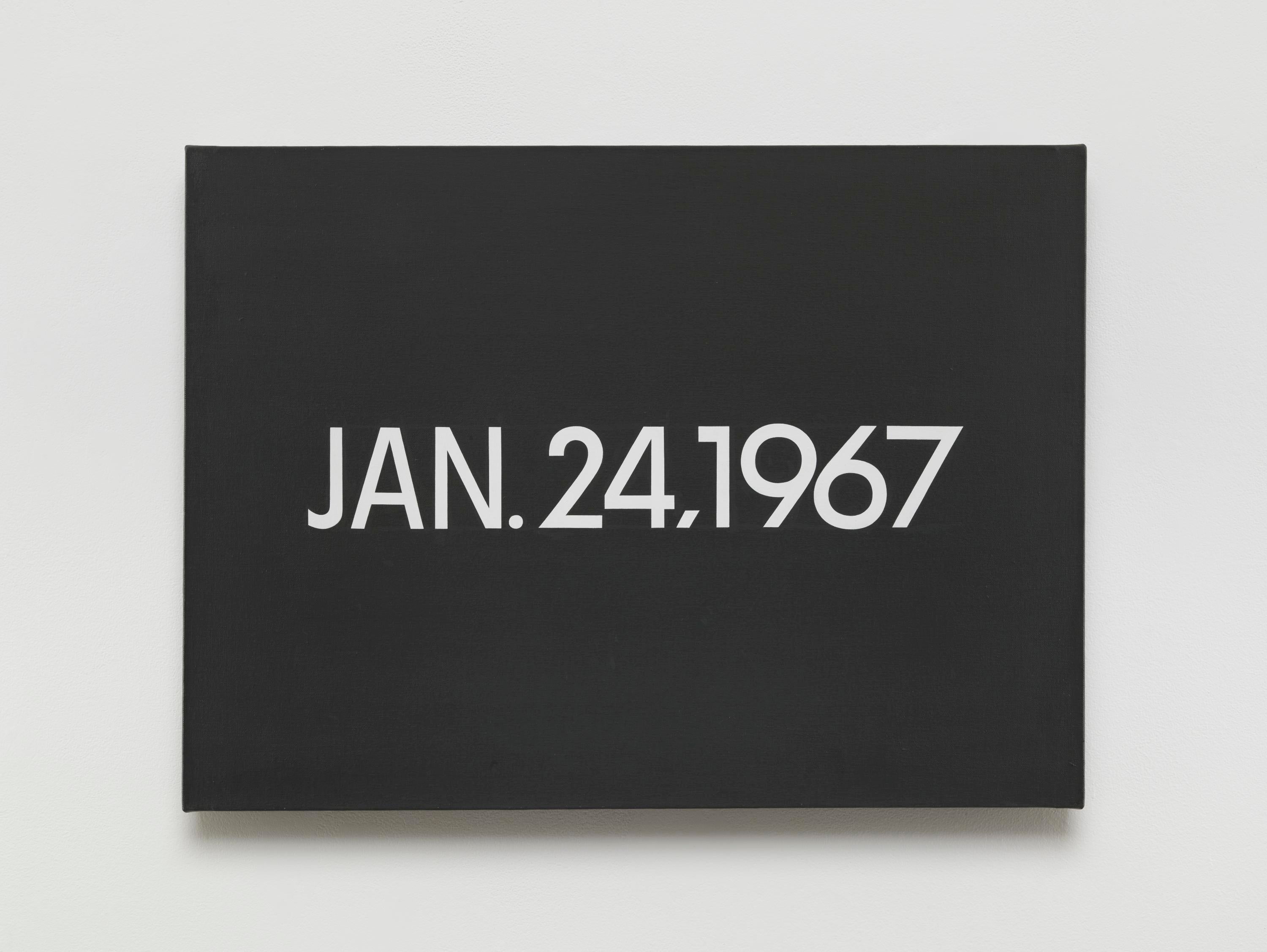 Un lienzo pintado con un fondo gris oscuro sólido y un texto blanco que dice "JAN. 24, 1967".