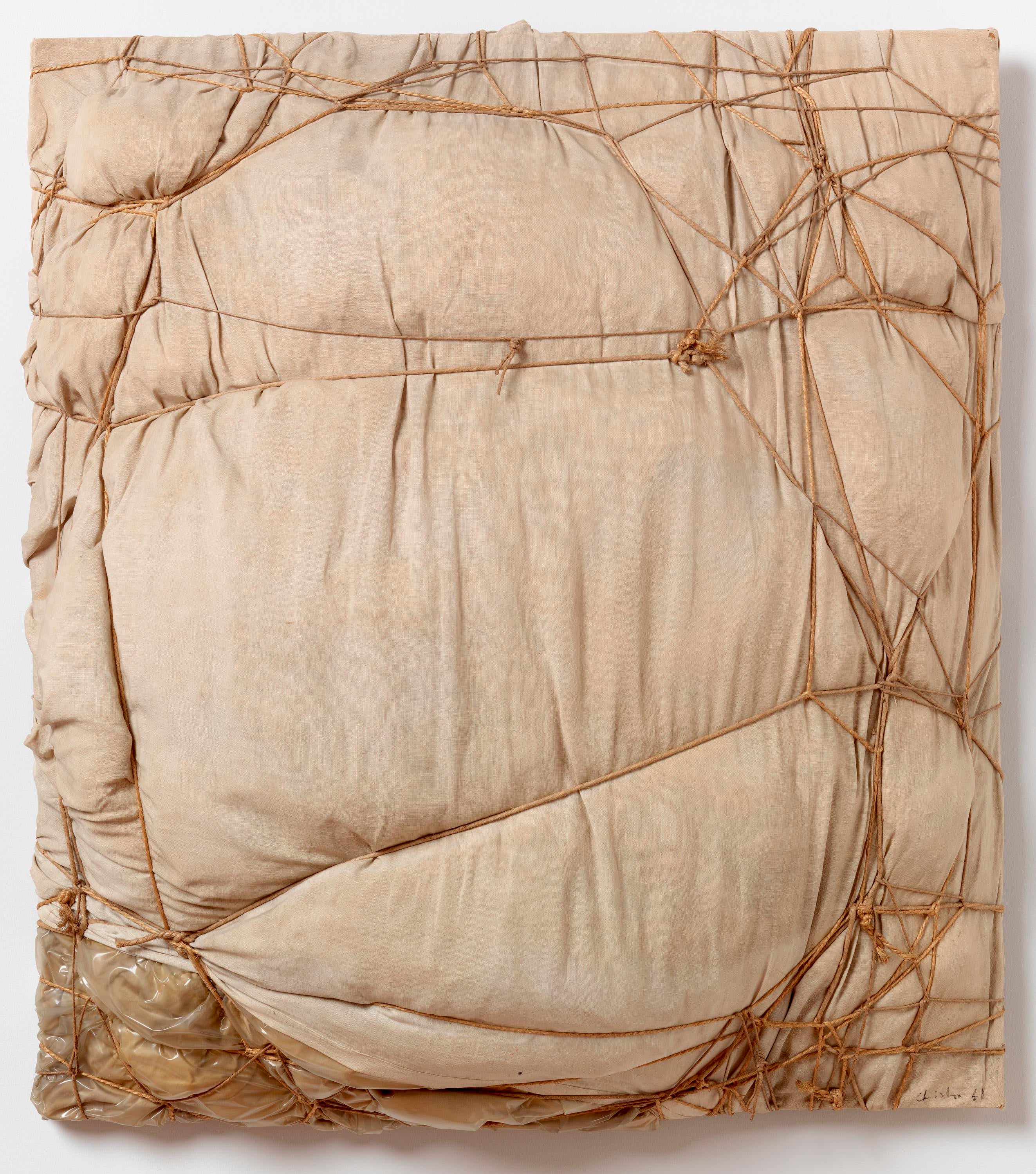 Fabric and plastic in a tall rectangular composition is tied all over with rope