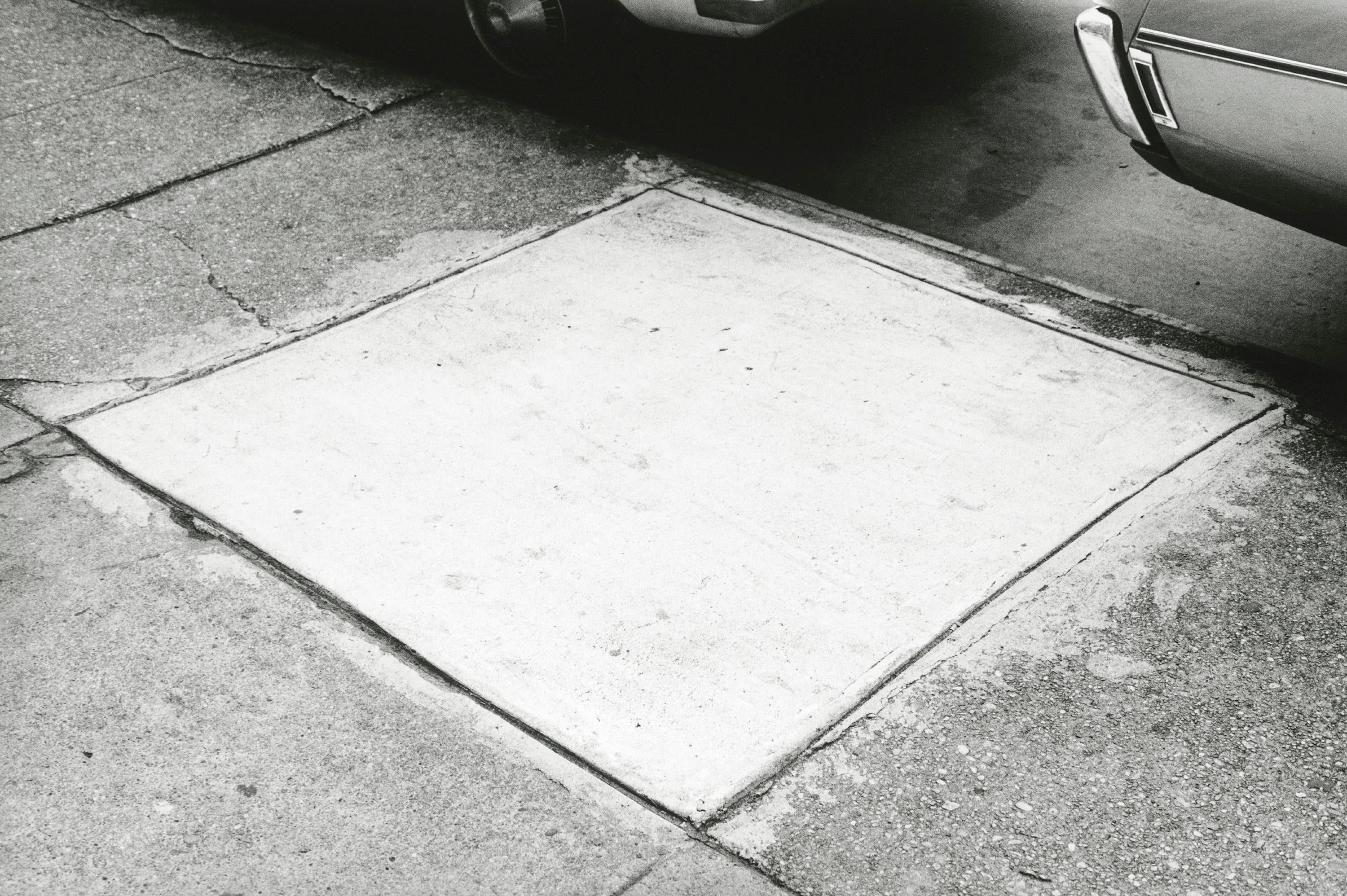 Una imagen en blanco y negro de un cuadrado de acera recién vertido.