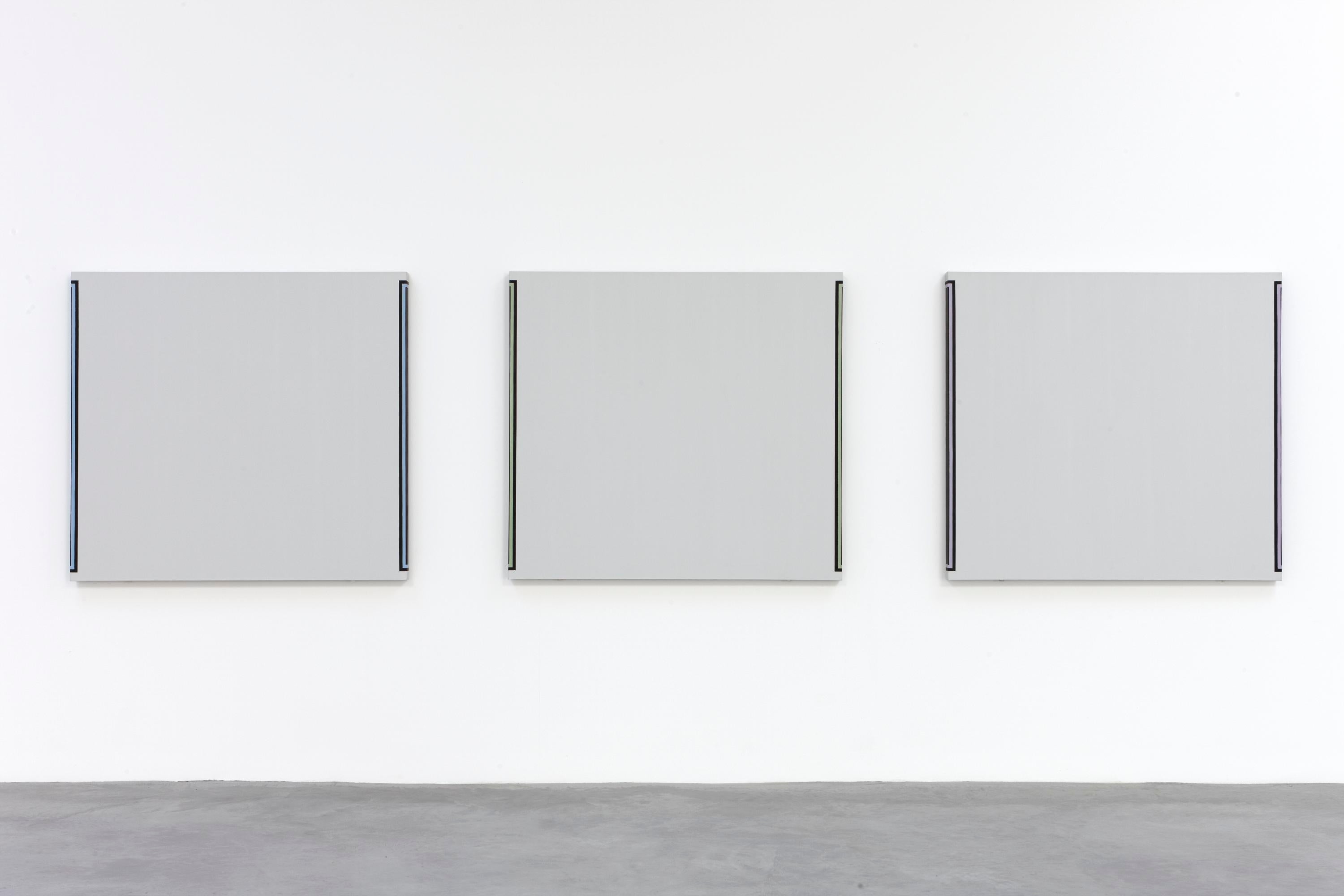 Three gray paintings are hung equidistantly on a gallery wall. Each has a stripe of color outlined in black wrapping around the edge of the canvas toward the wall.