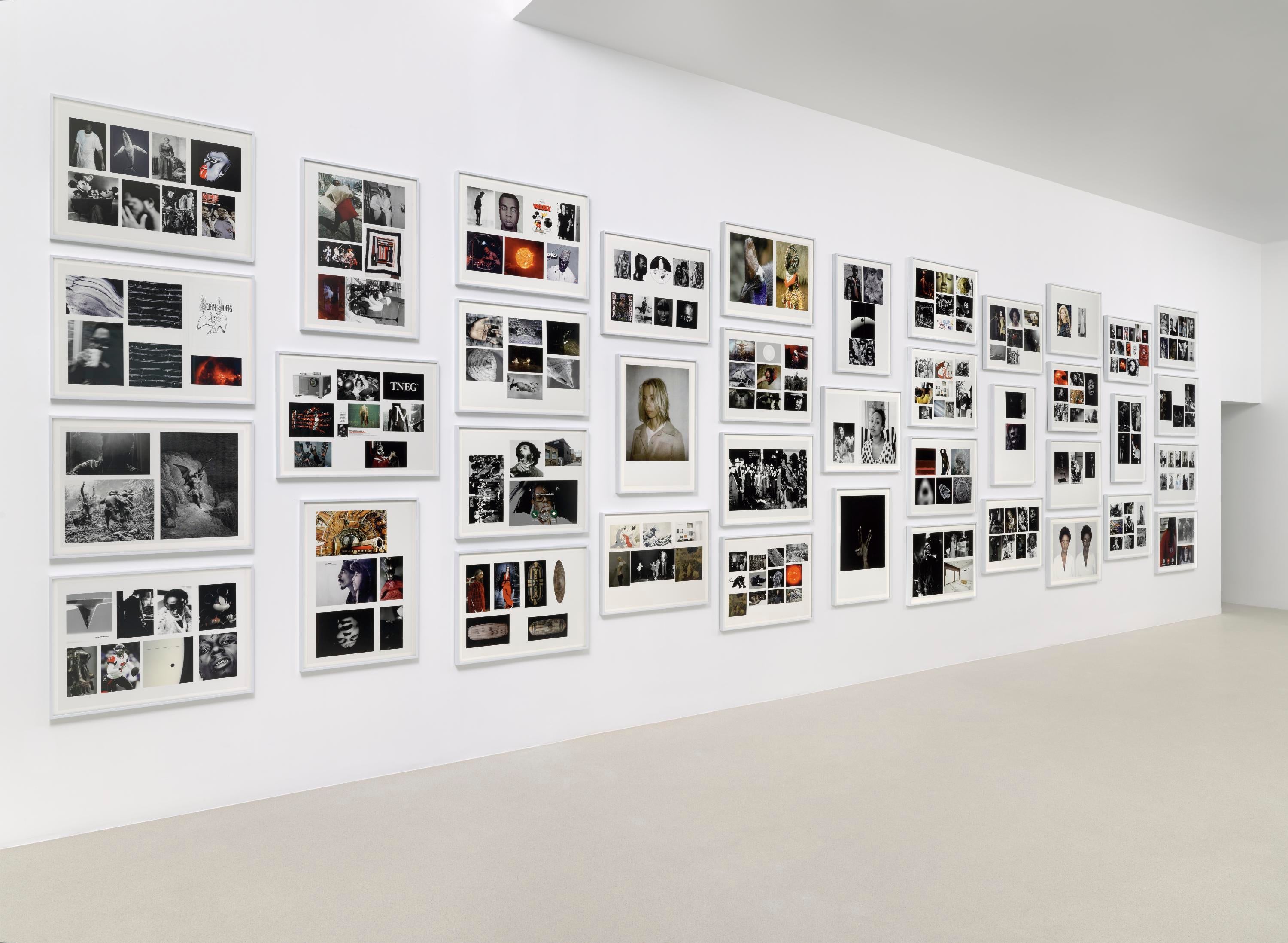 An array of various framed images is hung on a wall.