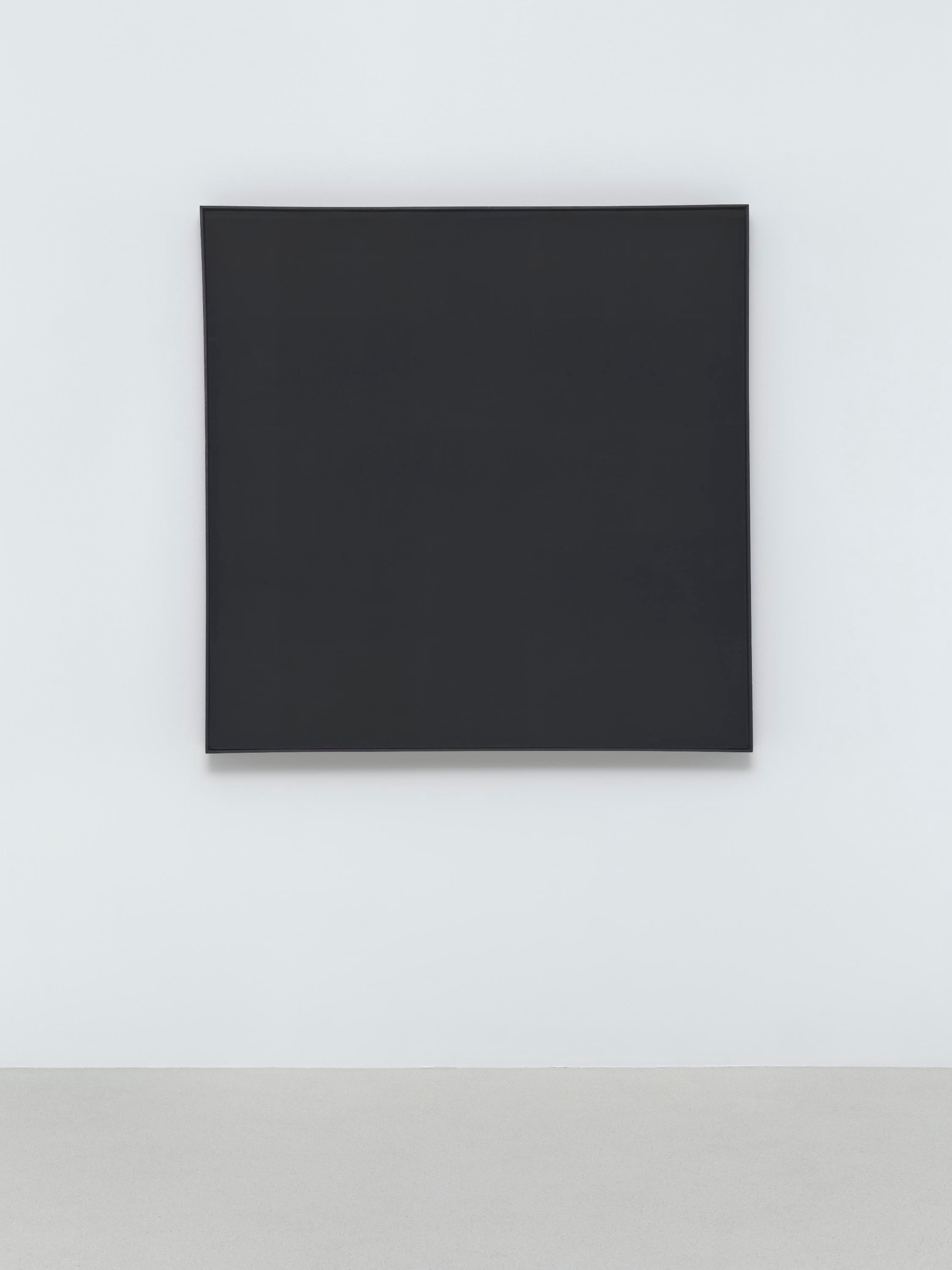 A black square painting hangs on a white wall.