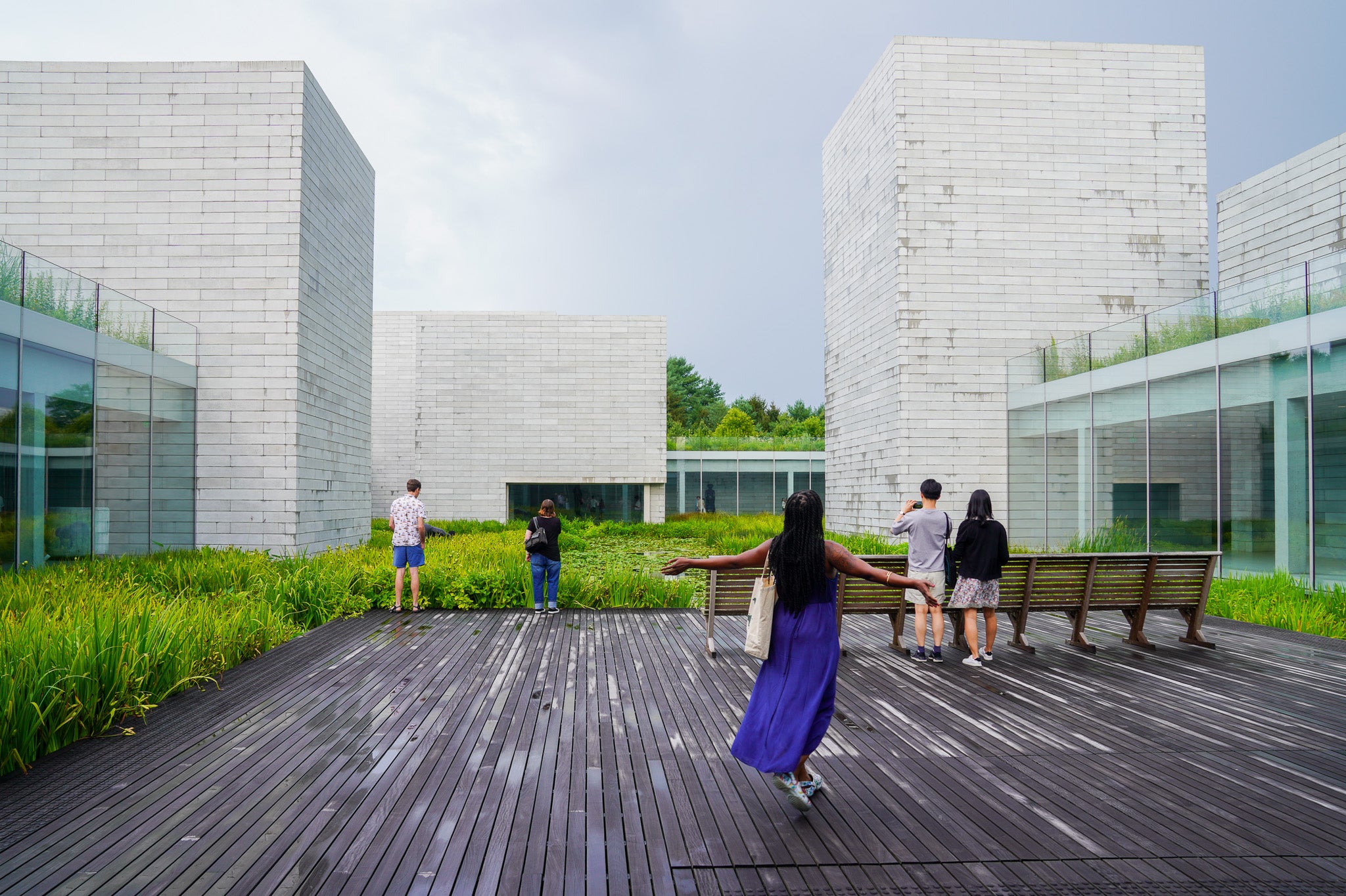 A woman in a purple dress walks outside after the rain