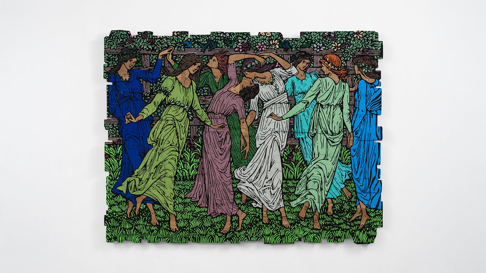 A painting of women dancing on cardboard hangs on a wall.