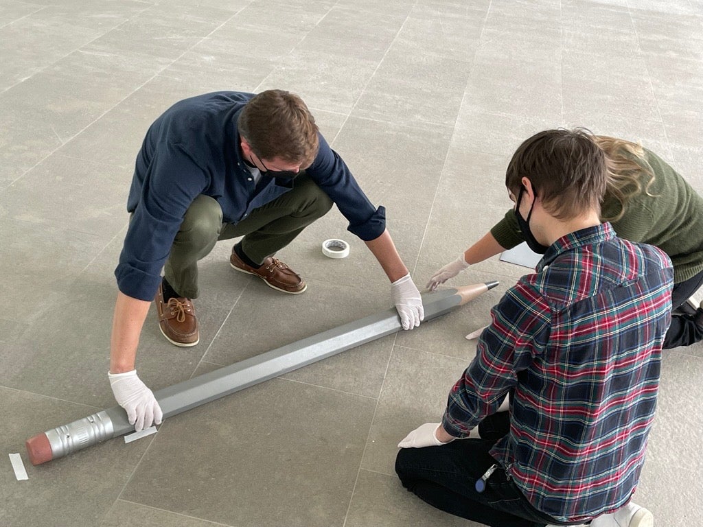 Conservadores instalando un lápiz grande