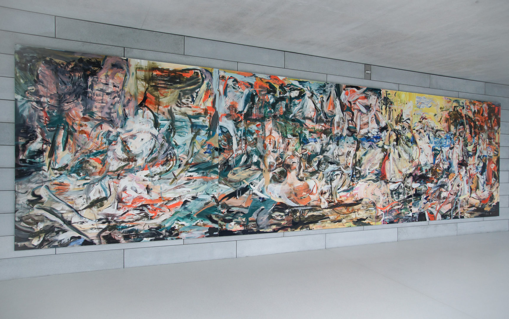 A large and colorful abstract painting hangs on a concrete wall.